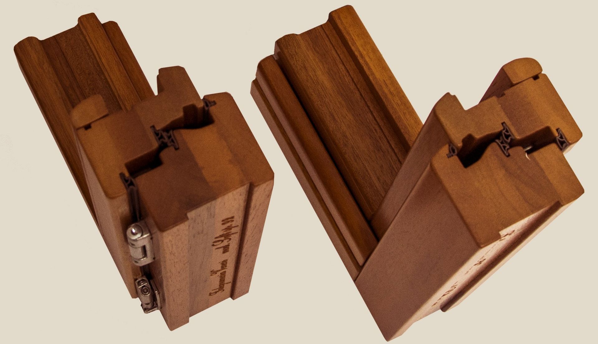 Due sezioni di telaio di finestra in legno, unite ad angolo, mettono in evidenza i profili ad incastro e le cerniere metalliche.